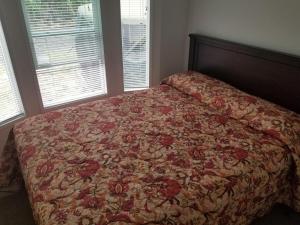 洛克威海灘的住宿－Paradise Cove RV Resort & Marina，一间卧室配有一张带花卉床罩的床
