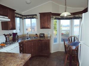 una cocina con armarios de madera, mesa y sillas en Paradise Cove RV Resort & Marina, en Rockaway Beach