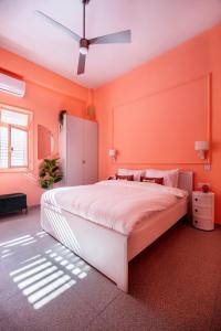 a bedroom with orange walls and a large bed at Glamorous Pink Pearl Studio/Beach/Parking/Netflix in Tel Aviv