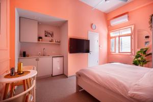 sypialnia z łóżkiem, stołem i umywalką w obiekcie Glamorous Pink Pearl Studio/Beach/Parking/Netflix w Tel Awiwie