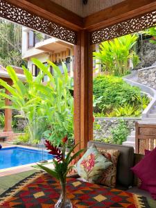 um alpendre com um sofá e um vaso com uma planta em Puri Kasih Gottlieb em Ubud