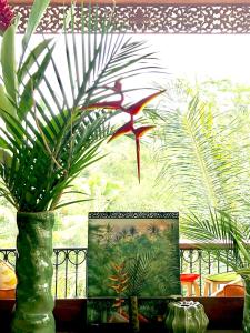 eine Vase mit einem Gemälde vor dem Fenster in der Unterkunft Puri Kasih Gottlieb in Ubud