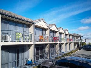 una fila de edificios de apartamentos con sillas en sus balcones en Azena Suites & Apartment, en Christchurch