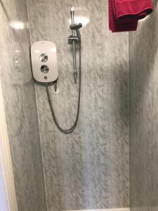 eine Dusche im Bad mit einem roten Handtuch in der Unterkunft Don Valley hotel Sheffield arena in Sheffield