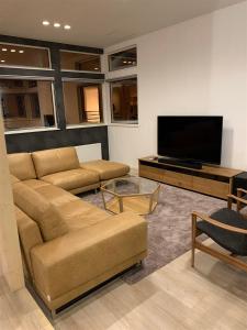 a living room with couches and a flat screen tv at Kalamunda House Rusutsu in Rusutsu