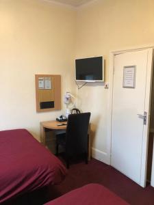 um quarto de hotel com uma secretária, uma cama e um computador em Don Valley hotel Sheffield arena em Sheffield