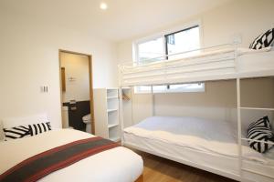 Un dormitorio con dos literas y una ventana. en Apartments Hakuba, en Hakuba