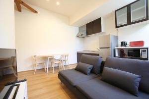 a living room with a couch and a kitchen at Apartments Hakuba in Hakuba