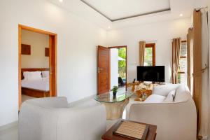 烏魯瓦圖的住宿－Askara Villa Uluwatu，客厅配有沙发、桌子和床。