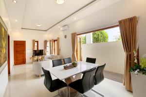 Un comedor y una sala de estar con mesa y sillas. en Askara Villa Uluwatu, en Uluwatu