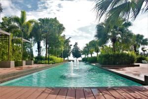 una fuente en un parque con palmeras en Sea View & Pool View & WiFi & Netflix at Iman Kazoku TimurBay Ville Studio 2BDR, en Kuantan