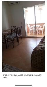 a dining room with a table and chairs and a patio at TANGER/ASILAH: APPART 50m2 FACE MER ET PISCINES, 5 PLACES, TOUT ÉQUIPÉ+WIFI+CLIM in Briech