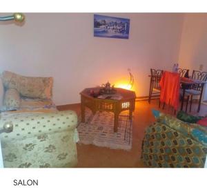 a living room with a couch and a table at TANGER/ASILAH: APPART 50m2 FACE MER ET PISCINES, 5 PLACES, TOUT ÉQUIPÉ+WIFI+CLIM in Briech