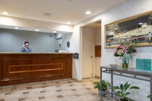 a man is standing behind a bar in a restaurant at Atherton Park Inn and Suites in Redwood City