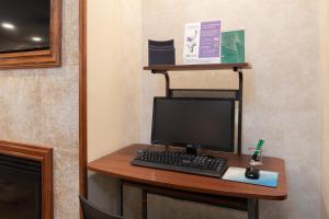 a desk with a computer and a keyboard and mouse at Atherton Park Inn and Suites in Redwood City