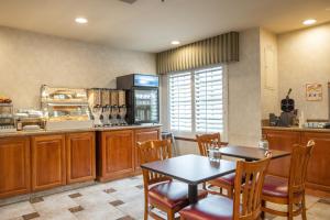 a restaurant with a table and chairs and a kitchen at Atherton Park Inn and Suites in Redwood City