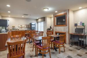 a restaurant with tables and chairs and a kitchen at Atherton Park Inn and Suites in Redwood City