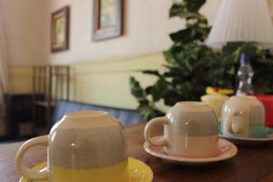dos tazas de té y platillos en una mesa de madera en Hostal Fiorenttina, en Valparaíso