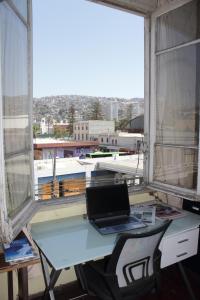 a laptop computer sitting on a desk in front of a window at Hostal Fiorenttina in Valparaíso