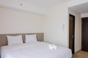 a white bed with two white pillows on it at Highest Value Studio Room at Annora Living Apartment By Travelio in Tangerang