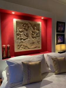 1 dormitorio con un cuadro sobre una cama con almohadas blancas en Villa Padi, en Canggu