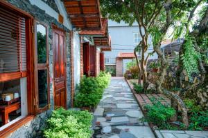 a walkway in front of a house with a tree at Tam Coc Ngo Đong Homestay in Ninh Binh
