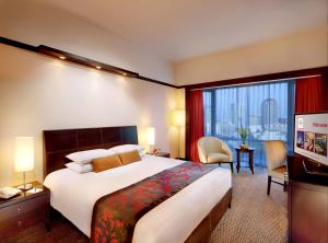 فندق ميلينيوم سيريه جاكارتا في جاكرتا: غرفة فندقية بسرير ونافذة كبيرة
