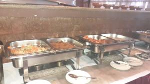 a buffet line with several trays of food at Bethan Amba ecovillage in Lalibela