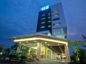 a building with a sign on top of it at Hotel Santika Pasir Koja Bandung in Bandung