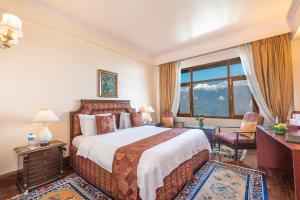 une chambre d'hôtel avec un lit et une fenêtre dans l'établissement The Elgin Mount Pandim - Heritage Resort & Spa, à Pelling