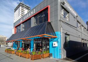 um restaurante com pessoas sentadas fora de um edifício em Urbanz em Christchurch