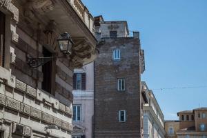 a tall brick building in the middle of a street at Relais Rione Ponte in Rome