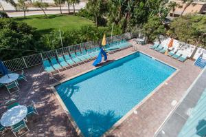 an overhead view of a swimming pool with chairs and a slide at South Beach Oceanfront Resort in St. Pete Beach