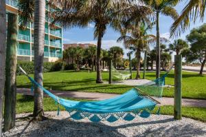 a hammock in a park with palm trees at South Beach Condo Hotel in St. Pete Beach