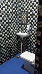 a bathroom with a white toilet and a sink at Radha Krishna Dham in Vrindāvan