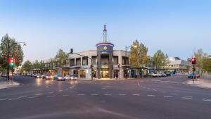 a large building with a clock on the top of it at Mawson Lakes Hotel in Adelaide