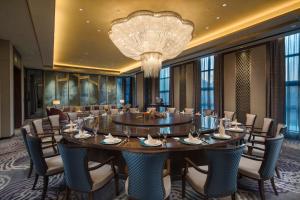 uma grande sala de jantar com uma grande mesa e cadeiras em Crowne Plaza Harbin Songbei, an IHG Hotel em Harbin