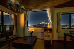 a living room with a view of a mountain through windows at Villa Fuji Bon Voyage Mori in Fujikawaguchiko +65 photos