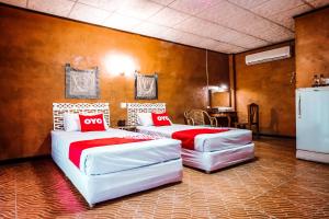 two beds in a room with red and white at OYO 490 Chiangsan Golden Land Resort2 in Chiang Saen