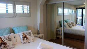 1 dormitorio con cama y espejo en THE TIN SHED Couples accommodation at Bay of Fires en Binalong Bay