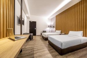 une chambre d'hôtel avec 2 lits et un ordinateur portable sur un bureau dans l'établissement Thy Executive Hotel, à Johor Bahru