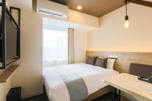 札幌市にあるホテル ウィングインターナショナル札幌 すすきののベッドとデスクが備わるホテルルームです。