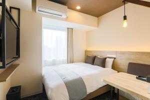une chambre d'hôtel avec un lit et un bureau dans l'établissement Hotel Wing International Sapporo Susukino, à Sapporo