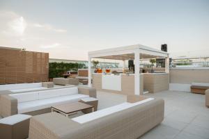 a rooftop patio with couches and a gazebo at Le Dune Suite Hotel in Porto Cesareo