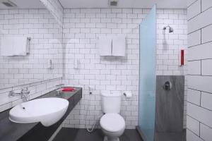 a bathroom with a white toilet and a sink at favehotel Ketapang in Ketapang