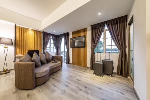 a living room with a couch and a television at Thy Executive Hotel in Johor Bahru