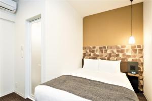 a bedroom with a large white bed and a window at M's Hotel Sanjo Wakoku in Kyoto