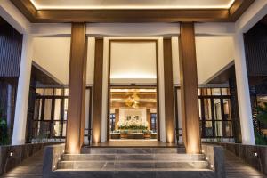 a lobby of a building with columns and a staircase at Areca Lodge in Pattaya