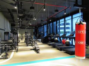 a gym with rows of exercise equipment and a large window at Frank Porter - Marquise Square in Dubai