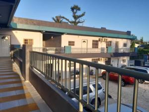 un balcón de un edificio con coches aparcados en un aparcamiento en Lee's comfort house en Chalan Kanoa